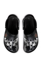 Top view of black slip-ons with white death moths, thorn roses, and mandala tattoo motifs