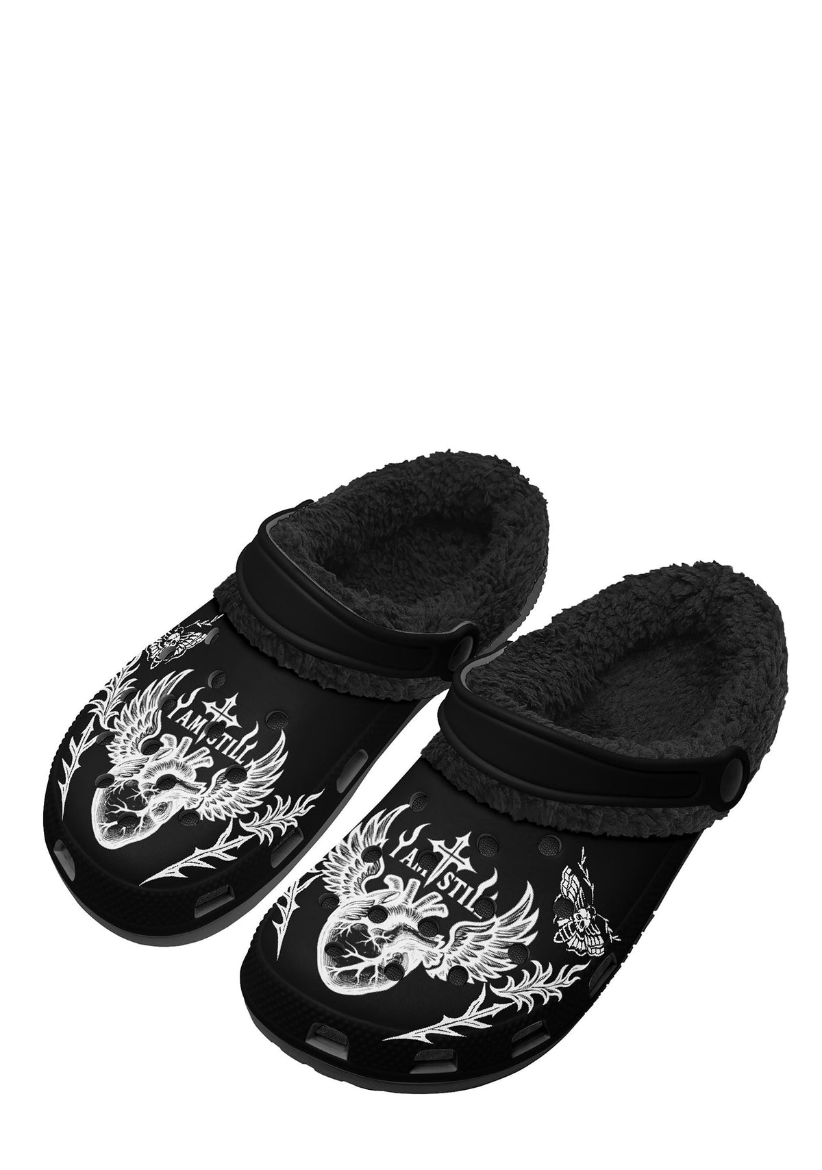 Front view of the black plush slippers featuring a white winged heart with a cross and the phrase "I Am Still" on the top