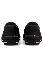 Heel view of black "Tattoos are Stupid" shoes with rainbow embroidered text on both shoes