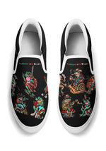 Black slip-ons with white sole and trim, decorated with funky frog tattoo graphics and colorful typography