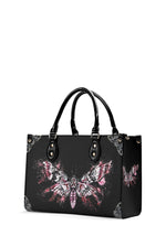 side view of death moth graffiti handbag with bold pink ink details on black background