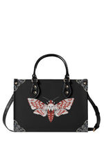 Gothic-style black handbag with red and white venom moth and ornate corner designs