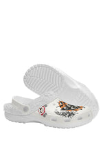 Underside of white fuzzy shoe showing floral and moth design